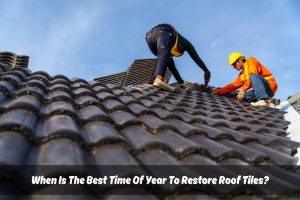 Two roofers safely restoring roof tiles at height, wearing safety vests, hard hats, and rubber shoes.